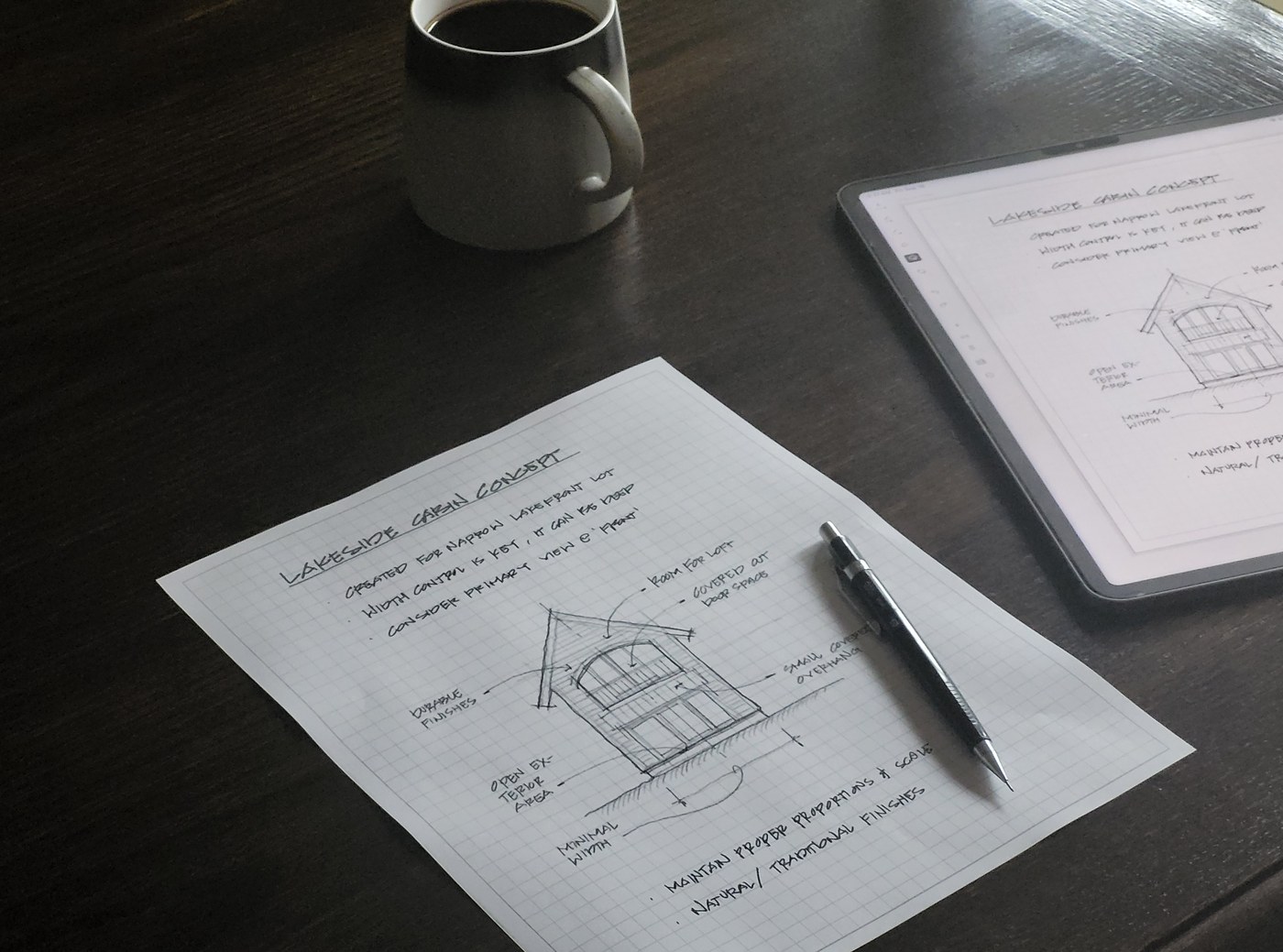 The same handwritten notebook page shown on an iPad screen and as a printed page side by side on a wooden table.